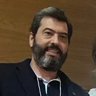 Foto de Paulo Lacava, com cabelos curtos e escuros, sorrindo e olhando diretamente para a câmera.